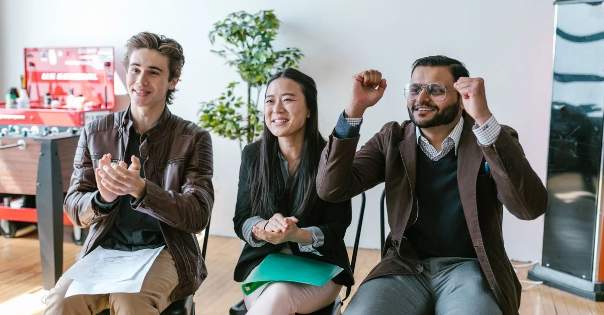 Un groupe d'entrepreneurs divers dans un espace de travail célébrant le succès et la motivation.